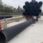 Layered backfill and compaction after HDPE corrugated pipe laying