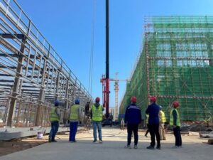 Construction workers on a building site, reinforcing steel bars for concrete foundation in a housing project