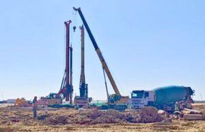 Concrete pouring process at a multi-story housing construction site with construction machinery